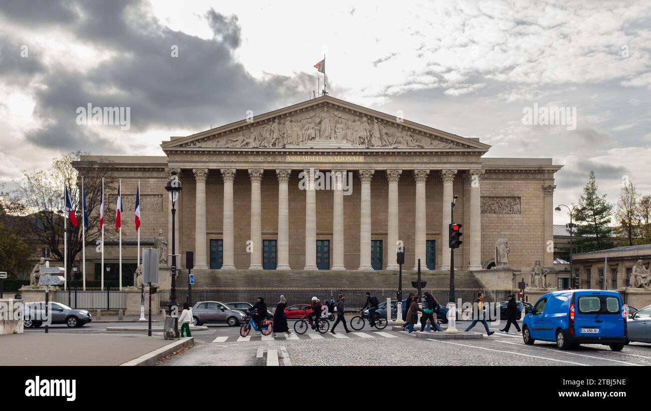 Parigi, Francia, 2023. Gente che cammina attraverso il Pont de la Concorde di fronte al Palais Bourbon che ospita l'Assemblea Nazionale Foto Stock