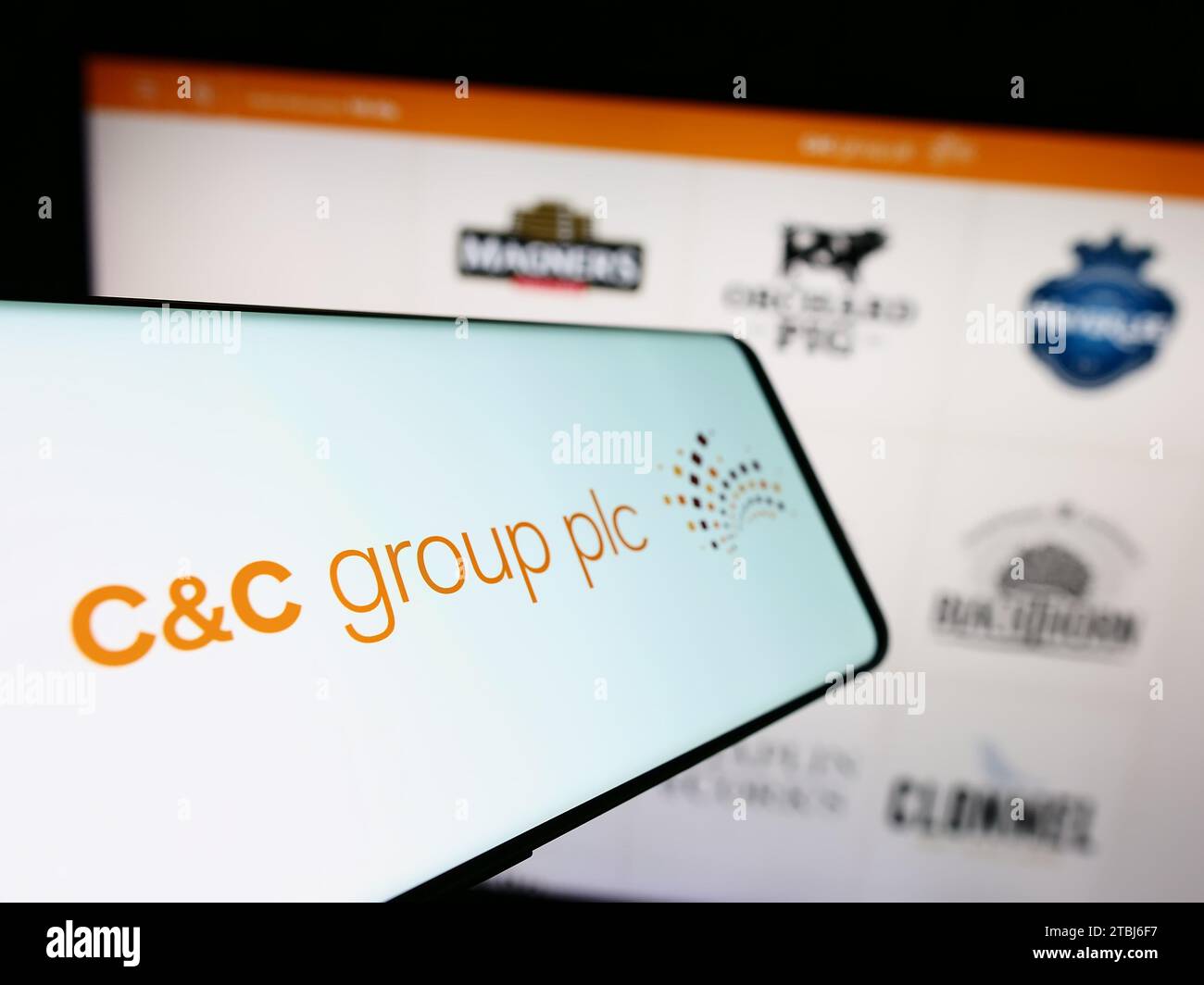Smartphone con logo dell'azienda irlandese di bevande alcoliche C e C Group plc (CC) davanti al sito Web. Mettere a fuoco il display centrale sinistro del telefono. Foto Stock
