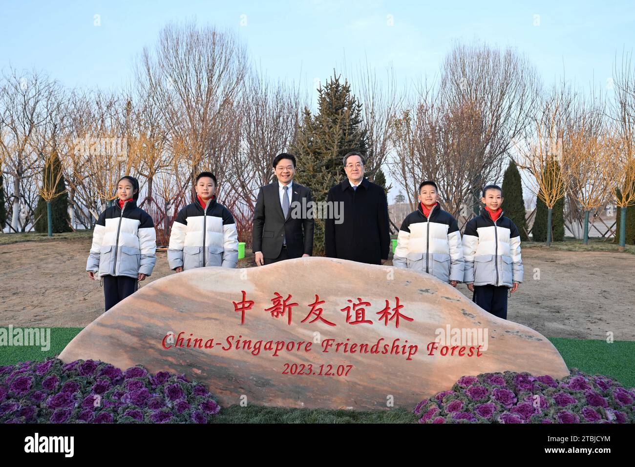 (231207) -- TIANJIN, 7 dicembre 2023 (Xinhua) -- Ding Xuexiang, membro del Comitato permanente dell'Ufficio politico del Comitato centrale del Partito Comunista Cinese e vicepresidente del Consiglio di Stato, posa per una foto di gruppo con il Vice primo Ministro e Ministro delle Finanze della Repubblica di Singapore Lawrence Wong di fronte alla China-Singapore Friendship Forest a Tianjin, nel nord della Cina, 7 dicembre 2023. Ding e Wong hanno co-presieduto la 19a riunione del Consiglio congiunto Cina-Singapore per la cooperazione bilaterale, la 24a riunione del Consiglio direttivo congiunto Cina-Singapore Suzhou Industrial Park Foto Stock