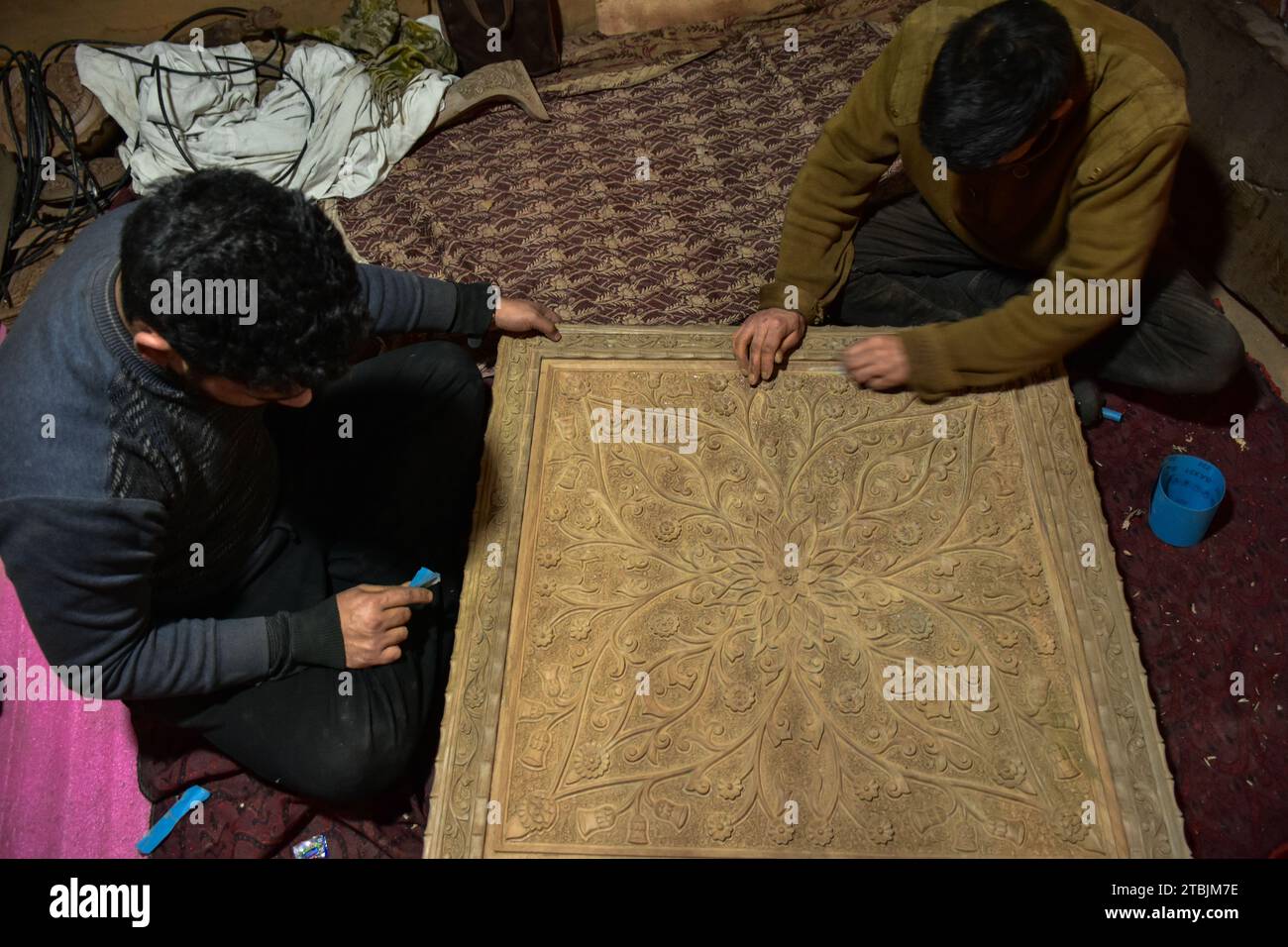Gli artigiani Kashmiri intagliano un oggetto artigianale in una fabbrica di intaglio del legno. Il Kashmir, il paradiso sulla terra, si riferisce alla bellezza naturale mozzafiato della regione e all'artigianato tradizionale. Insieme a molti altri tipi di arte, il Kashmir è rinomato per la sua tecnica unica di intaglio del legno. L'intaglio in legno Kashmiri è molto richiesto sia all'interno che all'esterno dello stato. Il suo mercato è cresciuto sia a livello locale che globale nel corso degli anni. Ma al giorno d'oggi, gli artigiani stanno lottando per mantenere viva questa arte. La maggior parte dei prodotti realizzati da questi artigiani non ottiene abbastanza profitto, a causa del quale questa nobile professione potrebbe essere Foto Stock