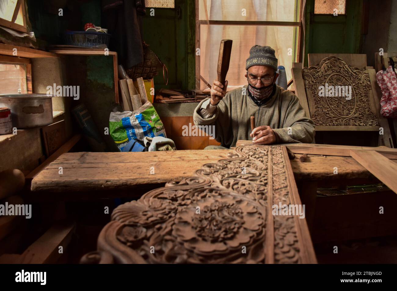 Srinagar, India. 7 dicembre 2023. Un artigiano Kashmiri intaglia un oggetto artigianale in una fabbrica di intaglio del legno. Il Kashmir, il paradiso sulla terra, si riferisce alla bellezza naturale mozzafiato della regione e all'artigianato tradizionale. Insieme a molti altri tipi di arte, il Kashmir è rinomato per la sua tecnica unica di intaglio del legno. L'intaglio in legno Kashmiri è molto richiesto sia all'interno che all'esterno dello stato. Il suo mercato è cresciuto sia a livello locale che globale nel corso degli anni. Ma al giorno d'oggi, gli artigiani stanno lottando per mantenere viva questa arte. La maggior parte dei prodotti realizzati da questi artigiani non ottiene abbastanza profitti, a causa di Foto Stock