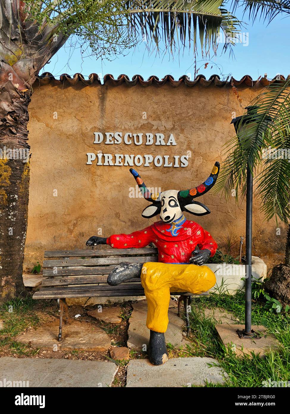 Una statua di un vitello cornuto arroccato sulla cima di una tradizionale panchina di legno aggiunge un fascino rustico a qualsiasi stanza Foto Stock