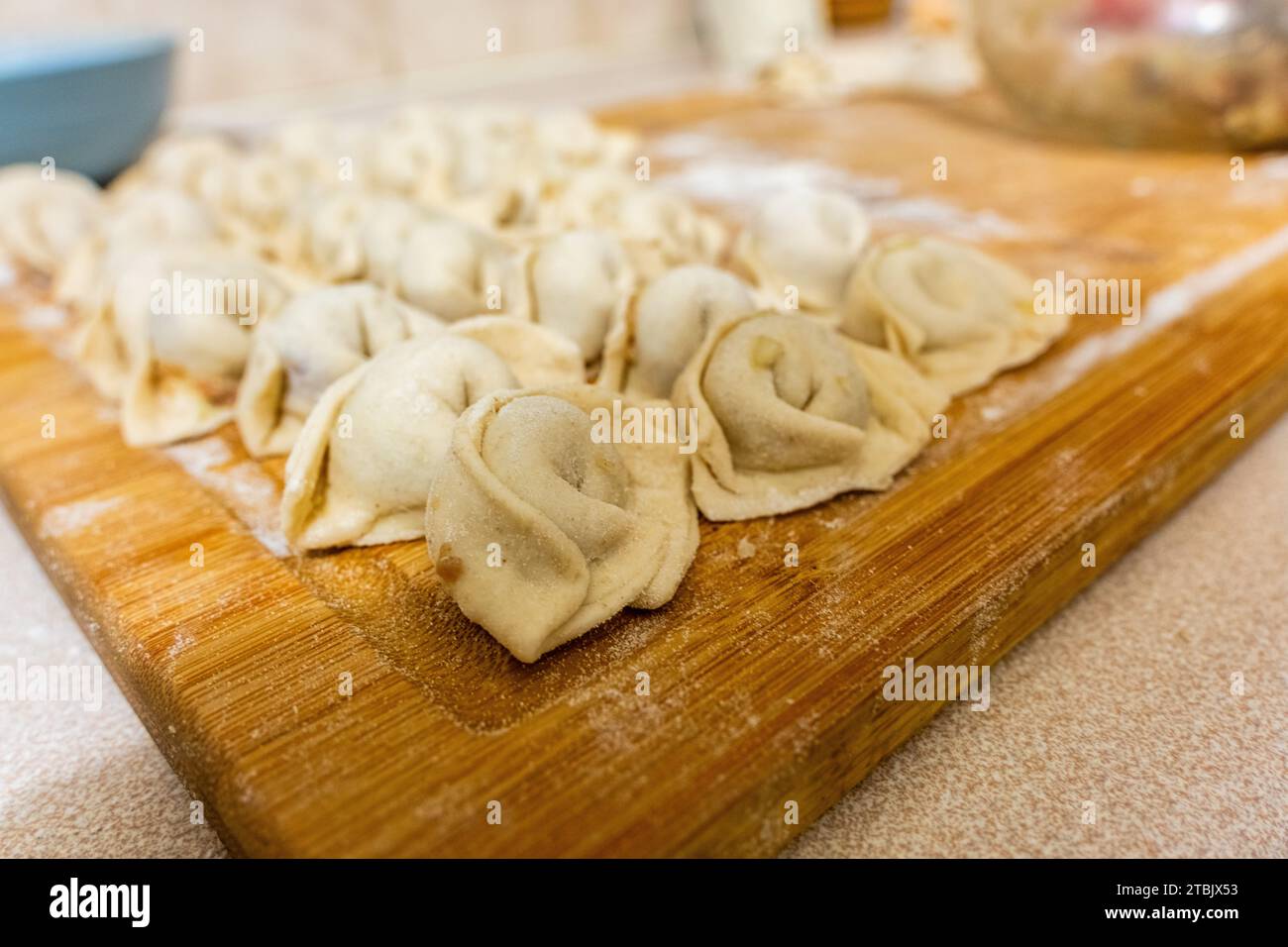 Chöchure uiguro appena fatto, piatto tipo wonton o tortellini, della provincia dello Xinjiang, Cina, su un tagliere pronto per essere cotto. Foto Stock