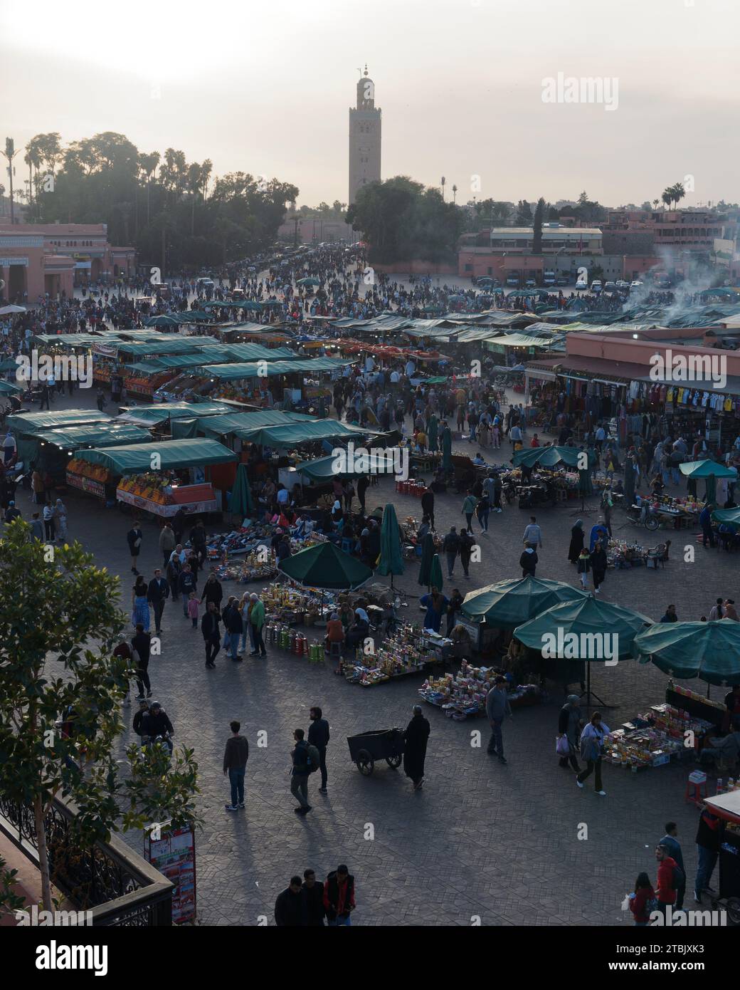 L'uomo spinge un carro in un mercato affollato di Jemaa el-Fnaa in una serata invernale a Marrakech, alias Marrakech, Marocco, 6 dicembre 2023 Foto Stock