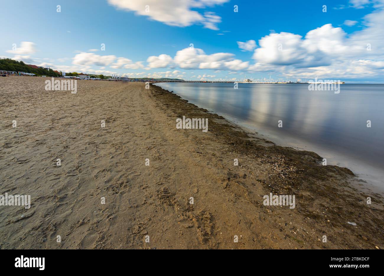 Sopot, Polonia - 22 luglio 2023: Splendida costa di grande spiaggia sabbiosa e del Mar Baltico in una giornata torbida e ventosa, vista a lunga esposizione Foto Stock