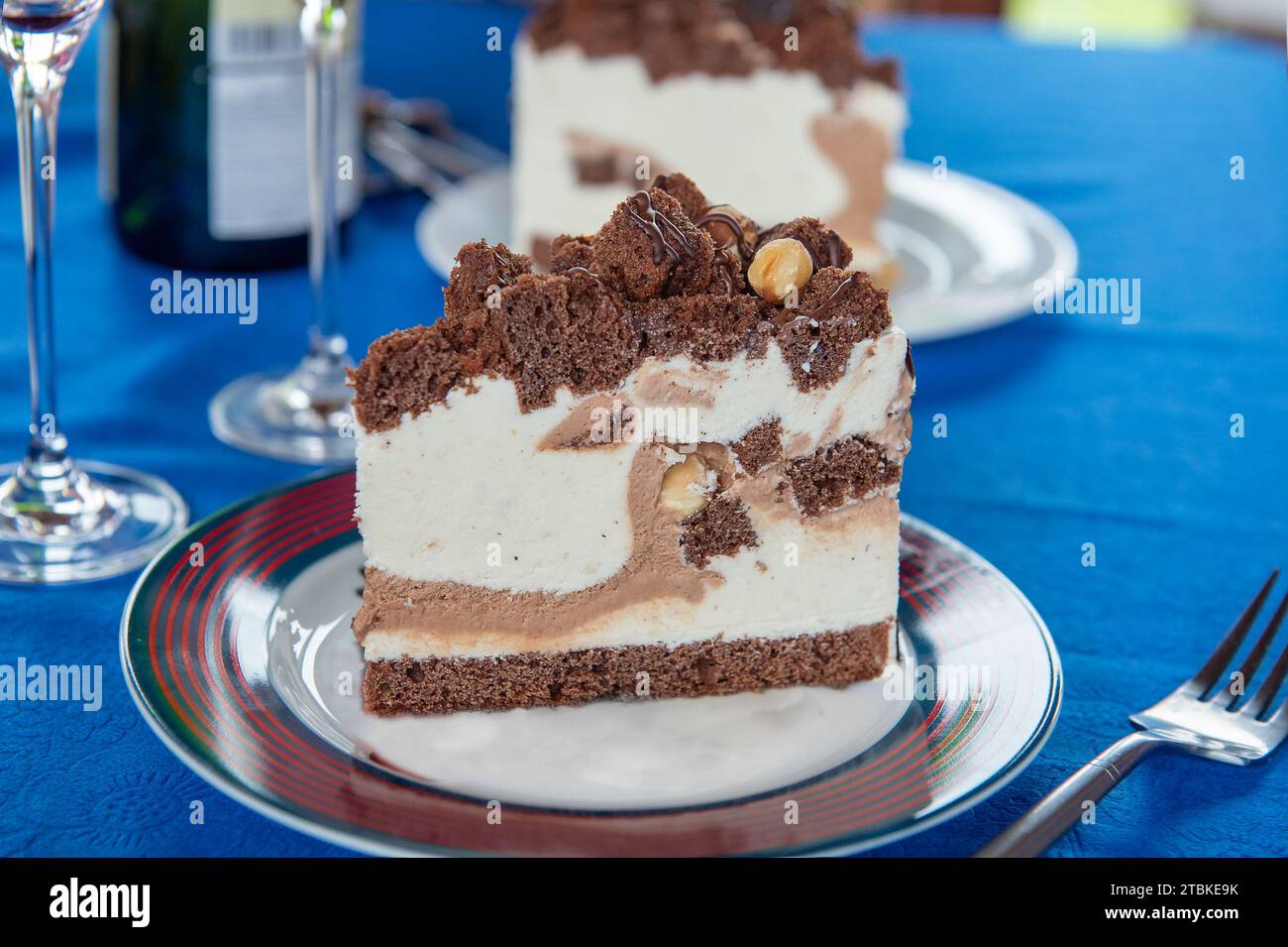 torta al cioccolato multistrato. Un piatto con un pezzo di deliziosa torta al cioccolato su un tavolo di legno. Primo piano. Foto Stock