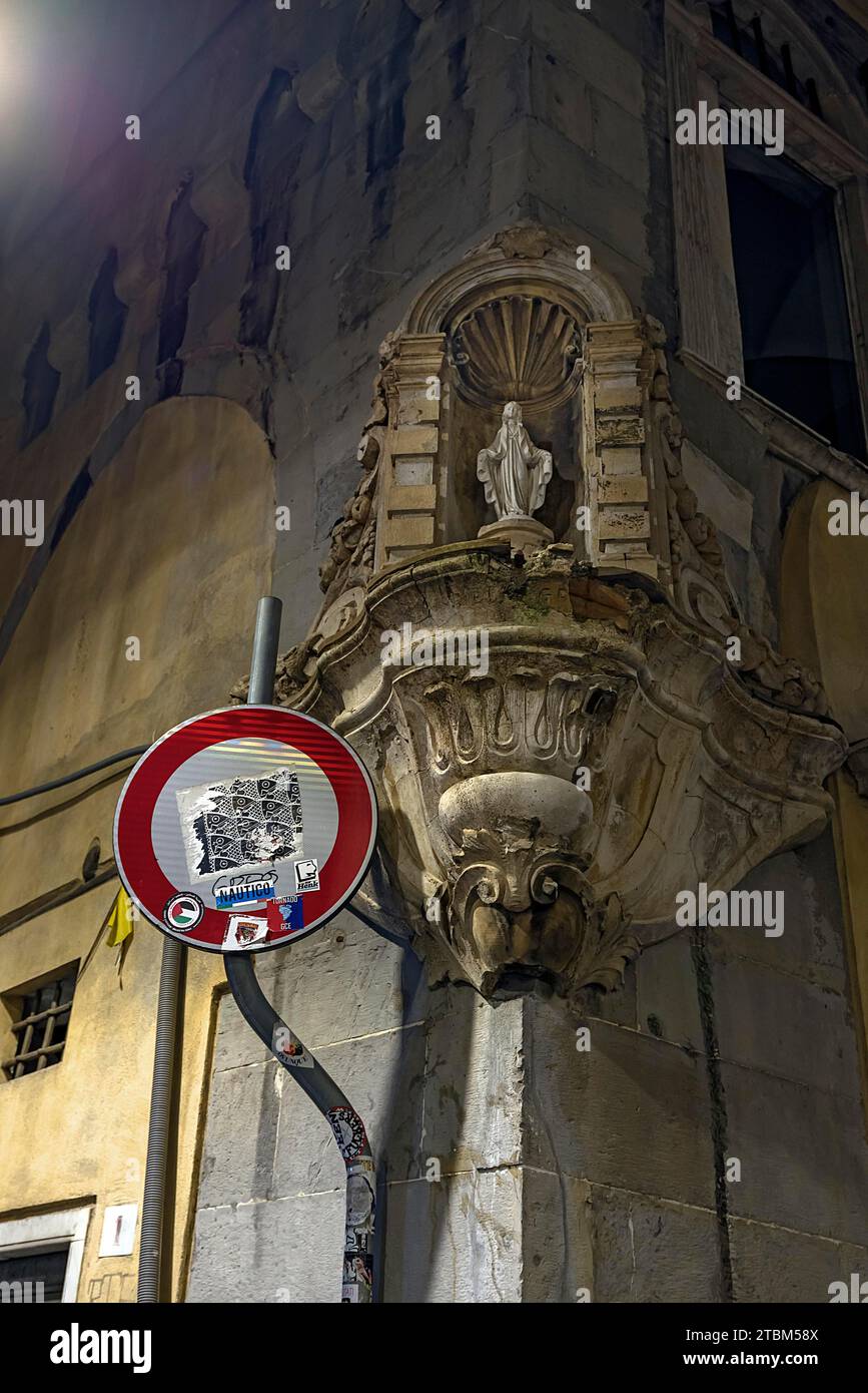 Figura della Madonna in una nicchia con cornice decorativa su una casa ad angolo nel centro storico di Genova, Italia Foto Stock