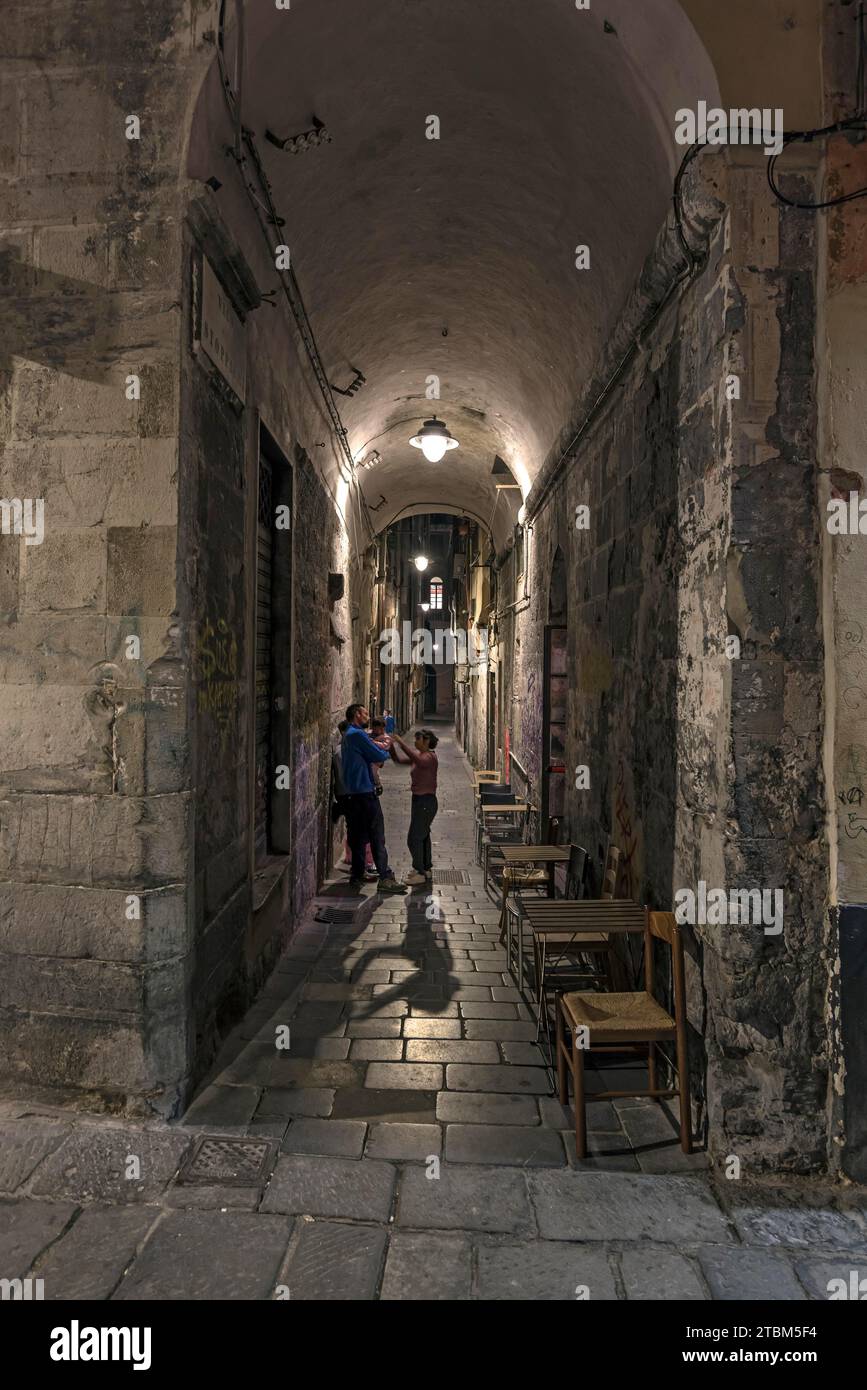 Giovane famiglia in un vicolo della città vecchia la sera, genere, Italia Foto Stock