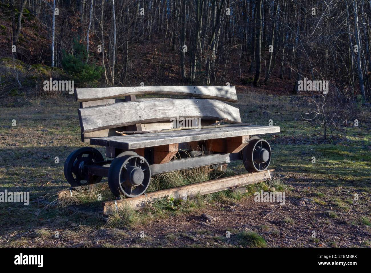 Panca in legno sulle ruote di un vecchio carrello minerario su una rotaia. Decorazioni nel parco Foto Stock