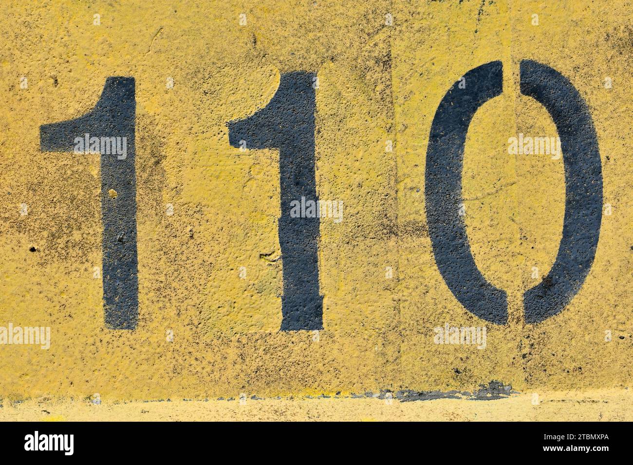 Il numero 110, centodieci; dipinto in nero e giallo; sfondo astratto per il disegno grafico simbolo di compleanni, date, anniversario. Foto Stock