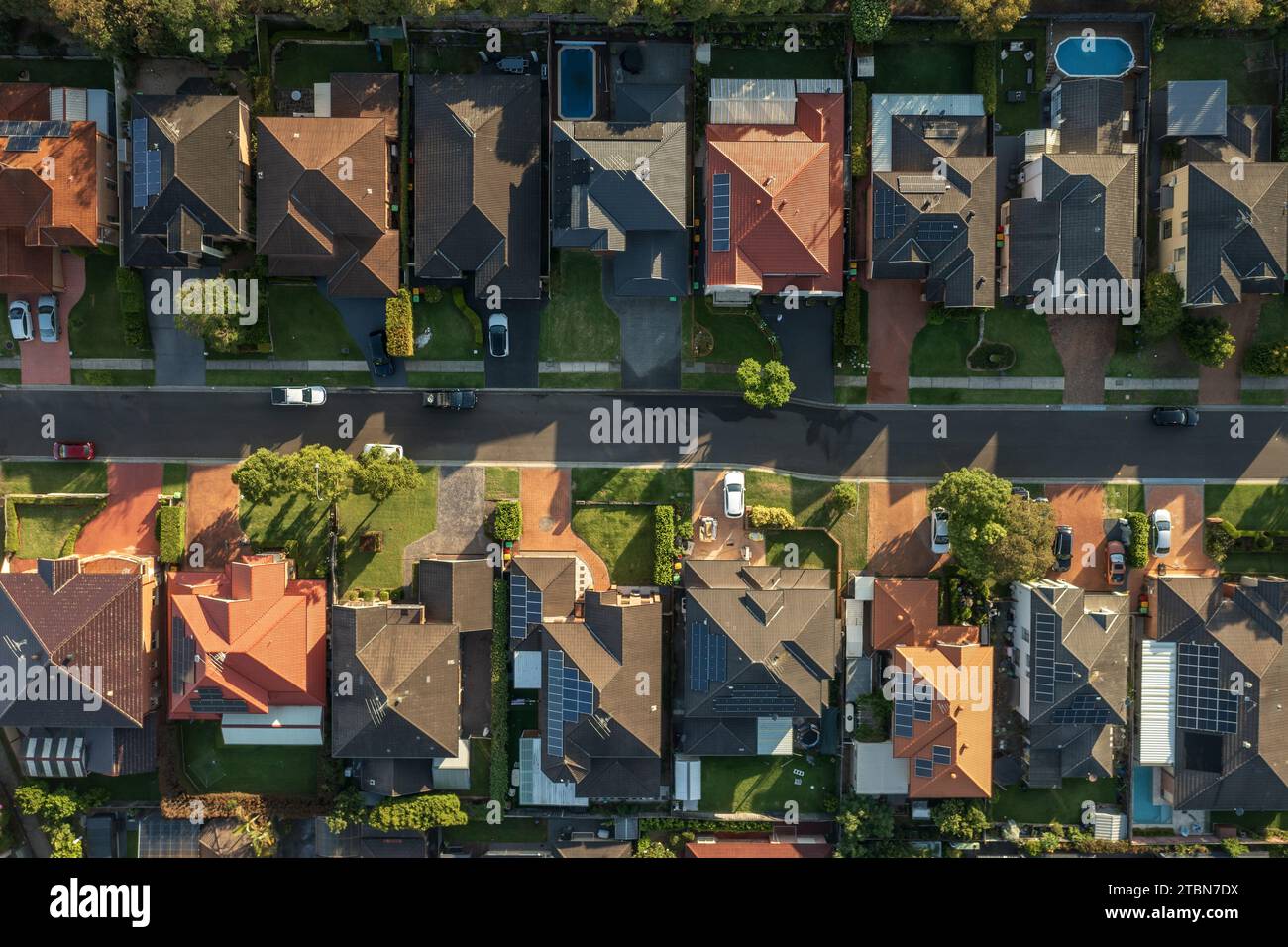 Dall'alto verso il basso la vista aerea di prima mattina di una tranquilla strada di quartiere fiancheggiata da case nella periferia esterna di Sydney, Australia. Foto Stock