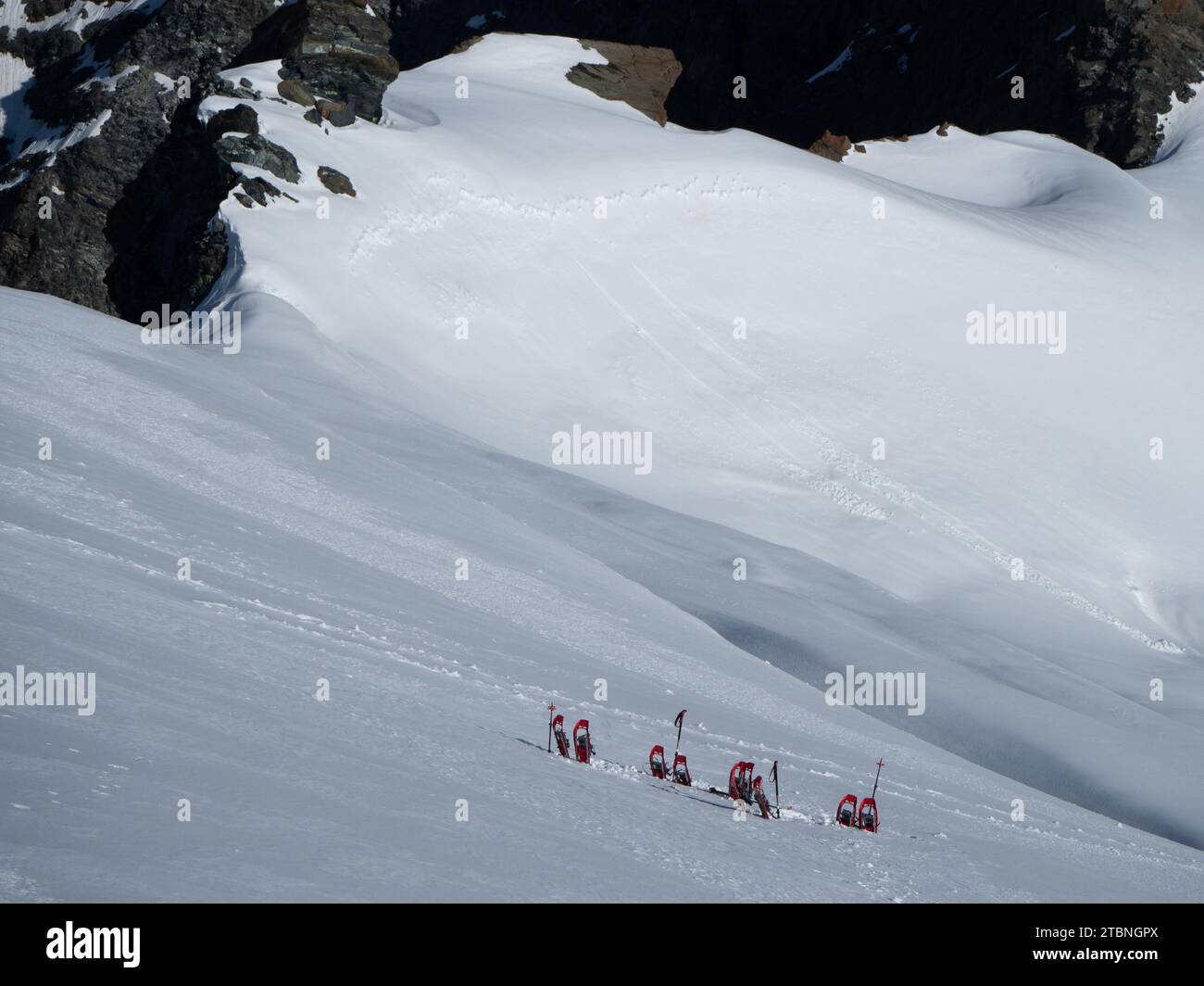 SaaS Fee, Svizzera - 16 giugno 2023: Deposito di racchette da neve sul ripido ghiacciaio per la salita alla vetta dello Strahlhorn Foto Stock
