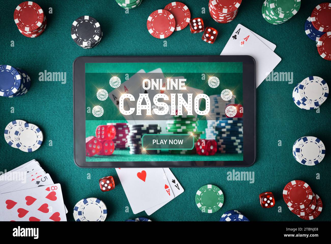 Concetto di giocare ai giochi di casinò online tramite un'app con un tablet con uno schermo che annuncia che si gioca a un casinò online su un tavolo con feltro verde fu Foto Stock