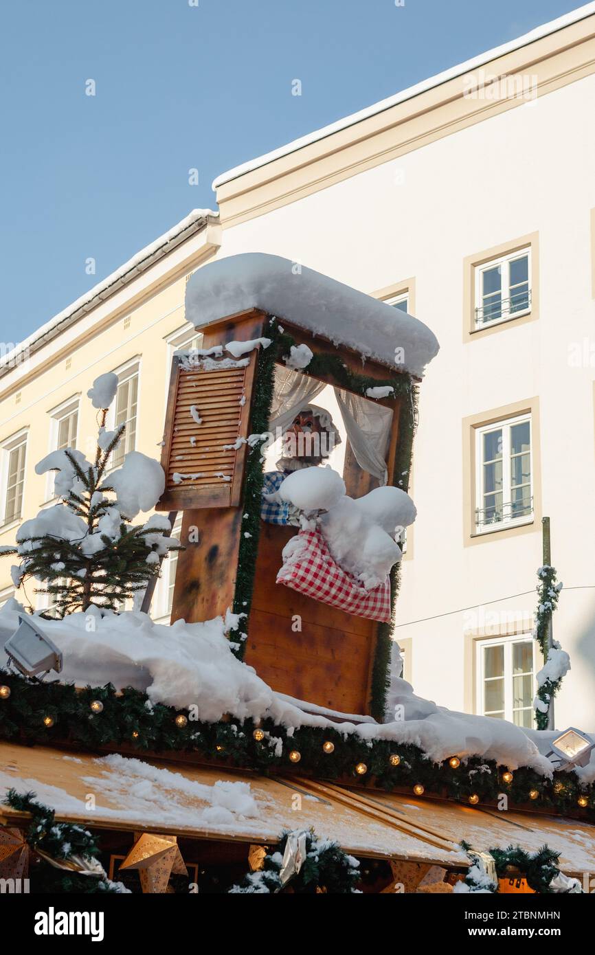 Rosenheim, Germania - 3 dicembre 2023: Stare con Frau Holle sul tetto scuotendo i letti al mercatino di Natale di Rosenheim Foto Stock