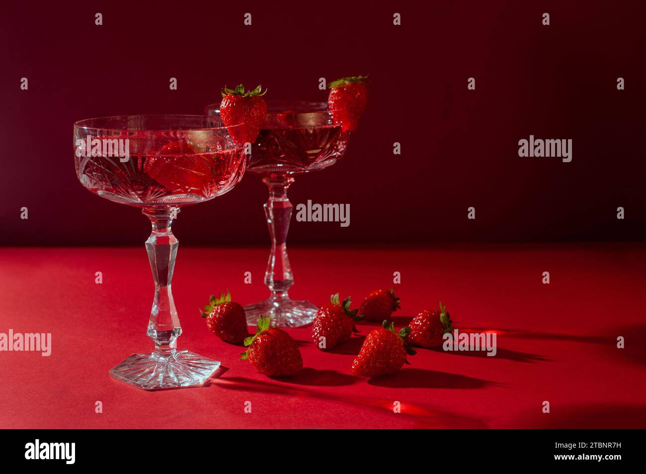 Due bicchieri di vino frizzante rosa su sfondo rosso per un romantico concetto di san valentino Foto Stock