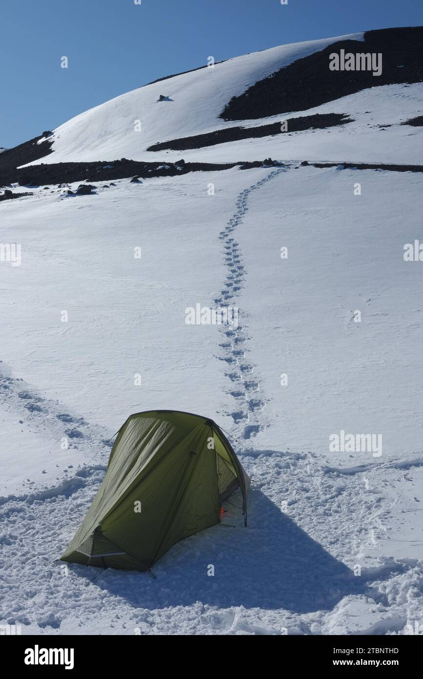 Campeggio sul versante innevato del cratere nord-est dell'Etna in inverno, piano Provenzana, Sicilia, Italia Foto Stock