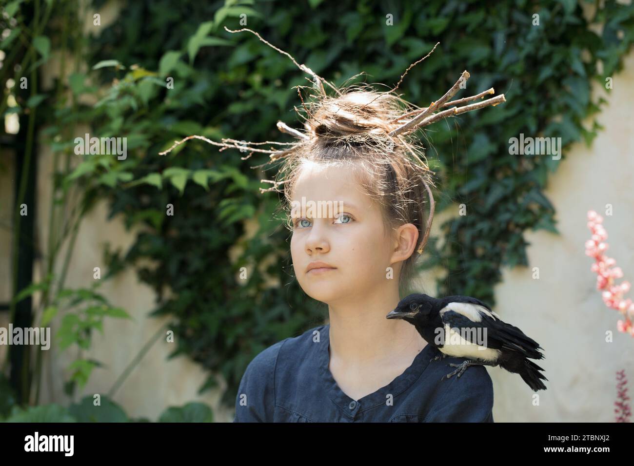 Una ragazza con un nido sulla testa e la sua gazza Foto Stock
