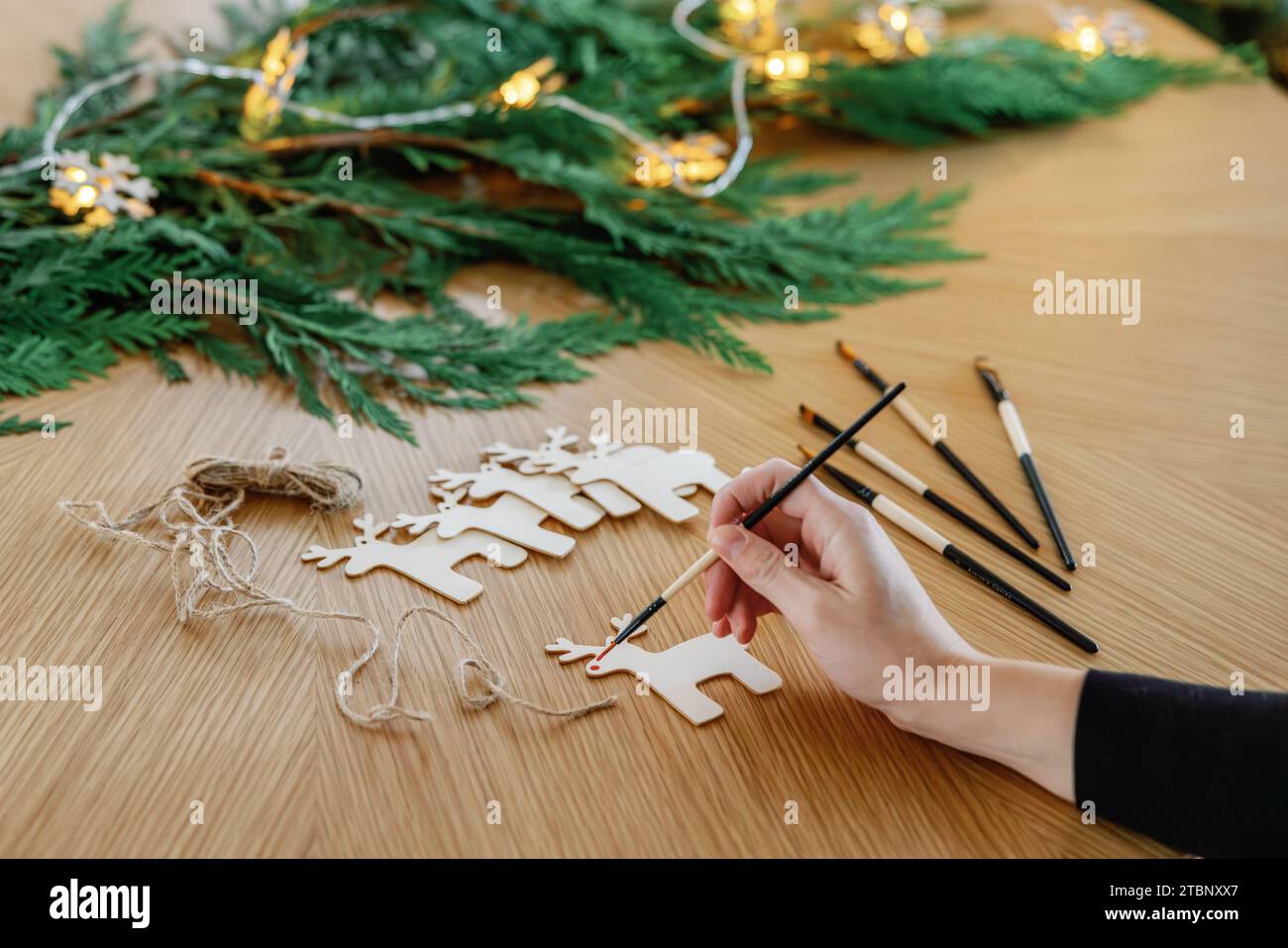 Dipingere ornamenti di renne in legno festosi Foto Stock