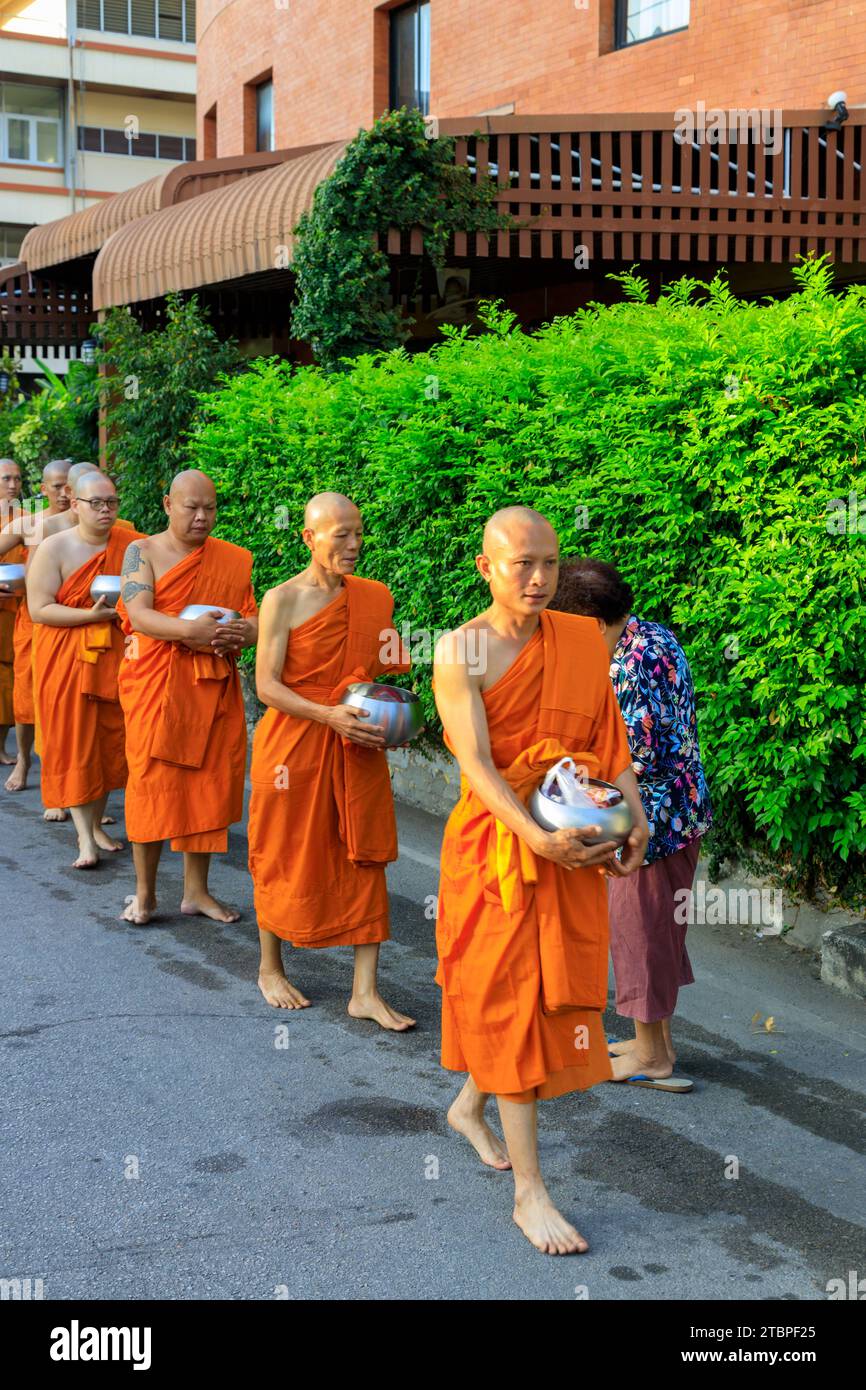 Lampang, Thailandia - 2 dicembre 2023: Monaci buddisti thailandesi Theravada che camminano per le elemosine mattutine a Nakhon Lampang, Thailandia. Foto Stock