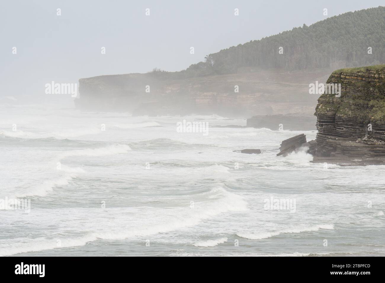 Onde forti che si infrangono sulle scogliere di Galizano in Cantabria Foto Stock