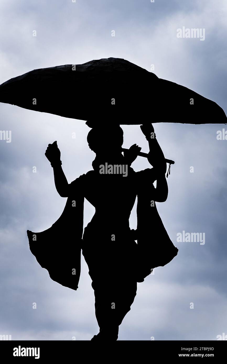 ripresa isolata retroilluminata del dio indù krishna con sfondo drammatico Foto Stock