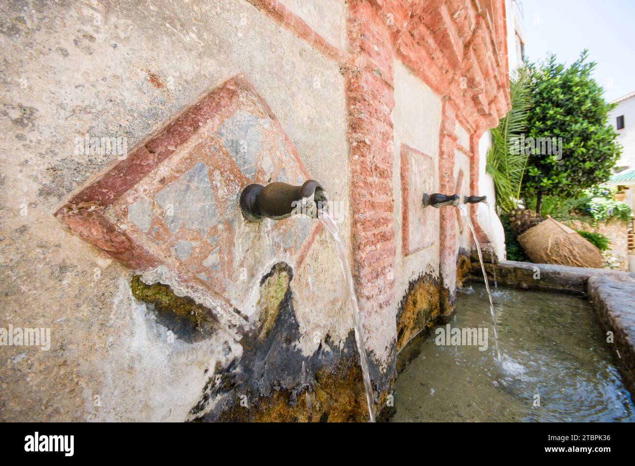 Tre fontane d'acqua all'aperto presentano disegni decorativi nativi e figure animali all'esterno di una grande struttura Foto Stock