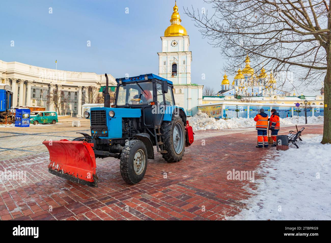 2023-12-05 Kiev, Ucraina. Lavoratori municipali di Kiev con trattori per strade urbane pulite e neve in piazza Mihailivskiy. Inverno a Kiev. Foto Stock