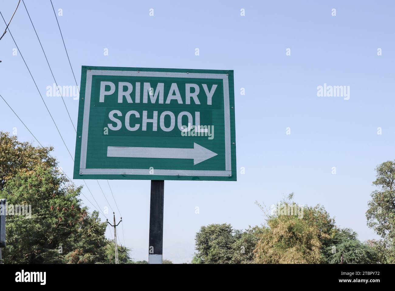 Cartello stradale con scritto Primary School con freccia a destra. Segnale scuola elementare sulla lavagna verde Foto Stock