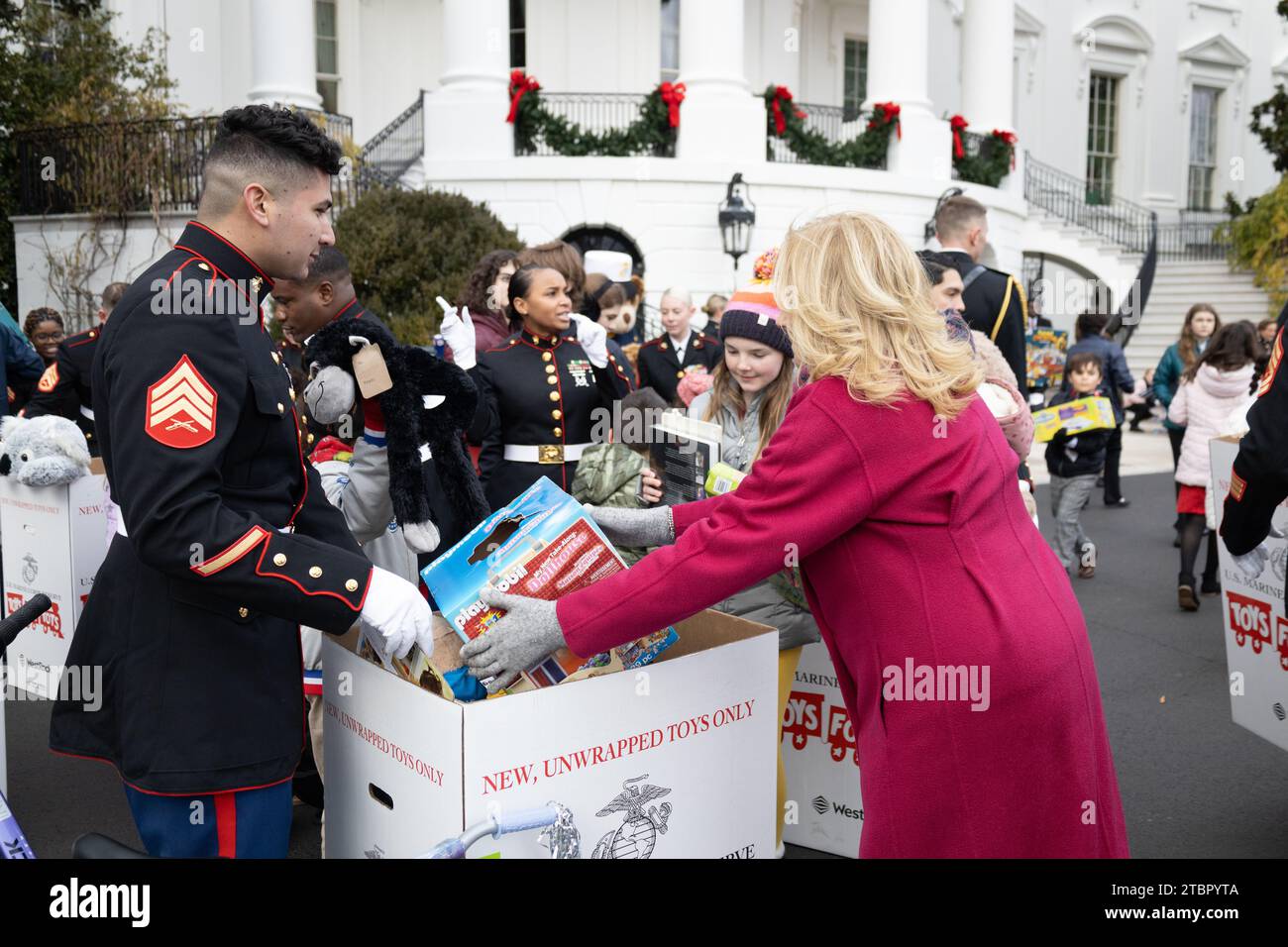 Washington, Stati Uniti. 6 dicembre 2023. U.S. First Lady Jill Biden, a destra, assistita dal sergente del corpo dei Marines Gabriel Perez, a sinistra, raccoglie giocattoli durante un evento Toys for Tots ospitato alla Casa Bianca, il 6 dicembre 2023 a Washington, DC ogni anno, il corpo dei Marines raccoglie e distribuisce 8 milioni di giocattoli per bambini in 830 comunità a livello nazionale. Crediti: CPL. Ryan Schmid/U.S. Marine Corps Photo/Alamy Live News Foto Stock