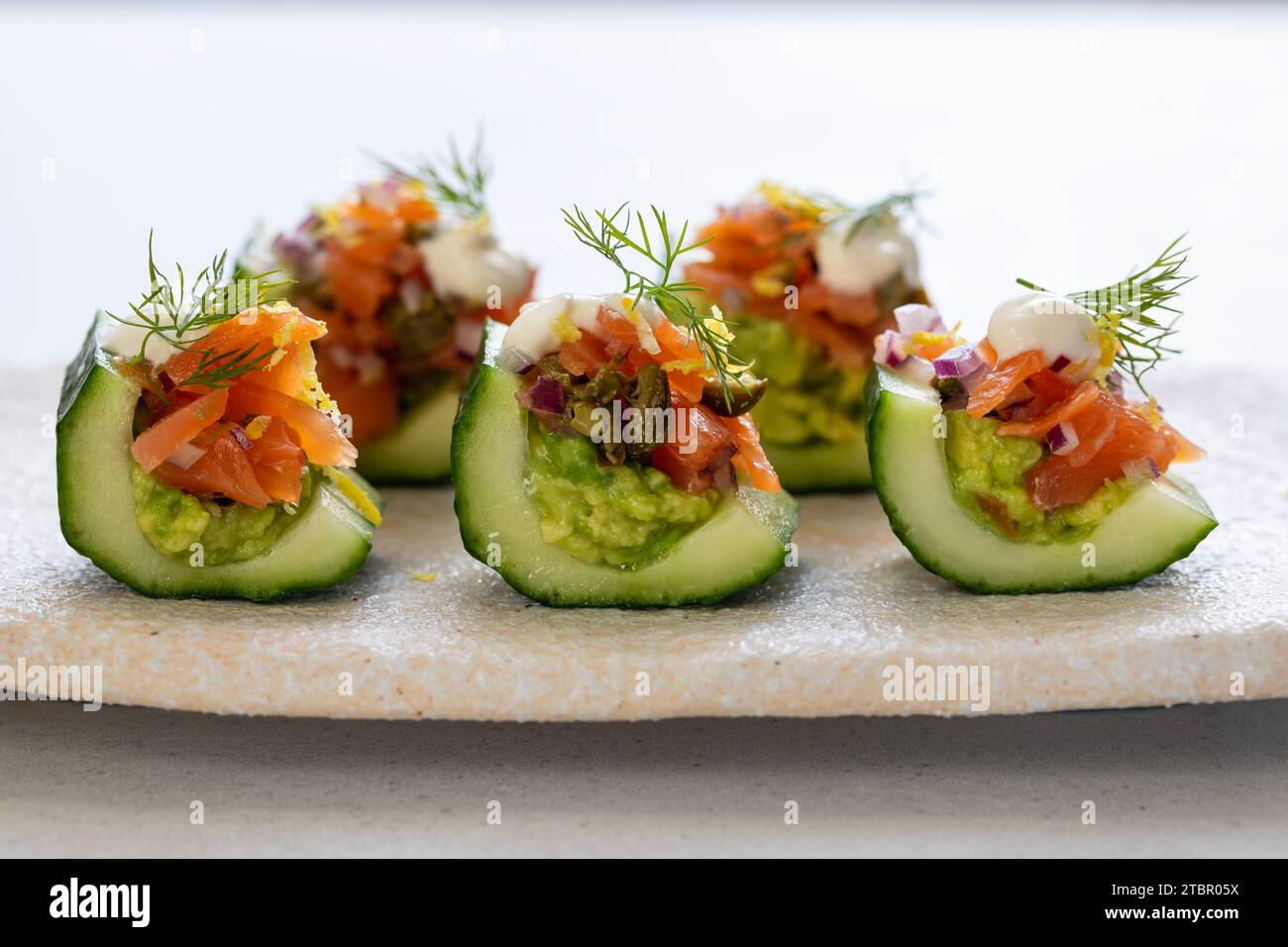 Tartine da festa, barche per cetrioli con avocado e salmone Foto Stock