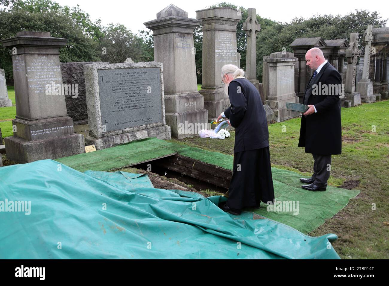 Funerale greco-ortodosso di Glasgow in Scozia alla necropoli di Glasgow - prete che versa olio d'oliva sul Coffin al committal Service Foto Stock