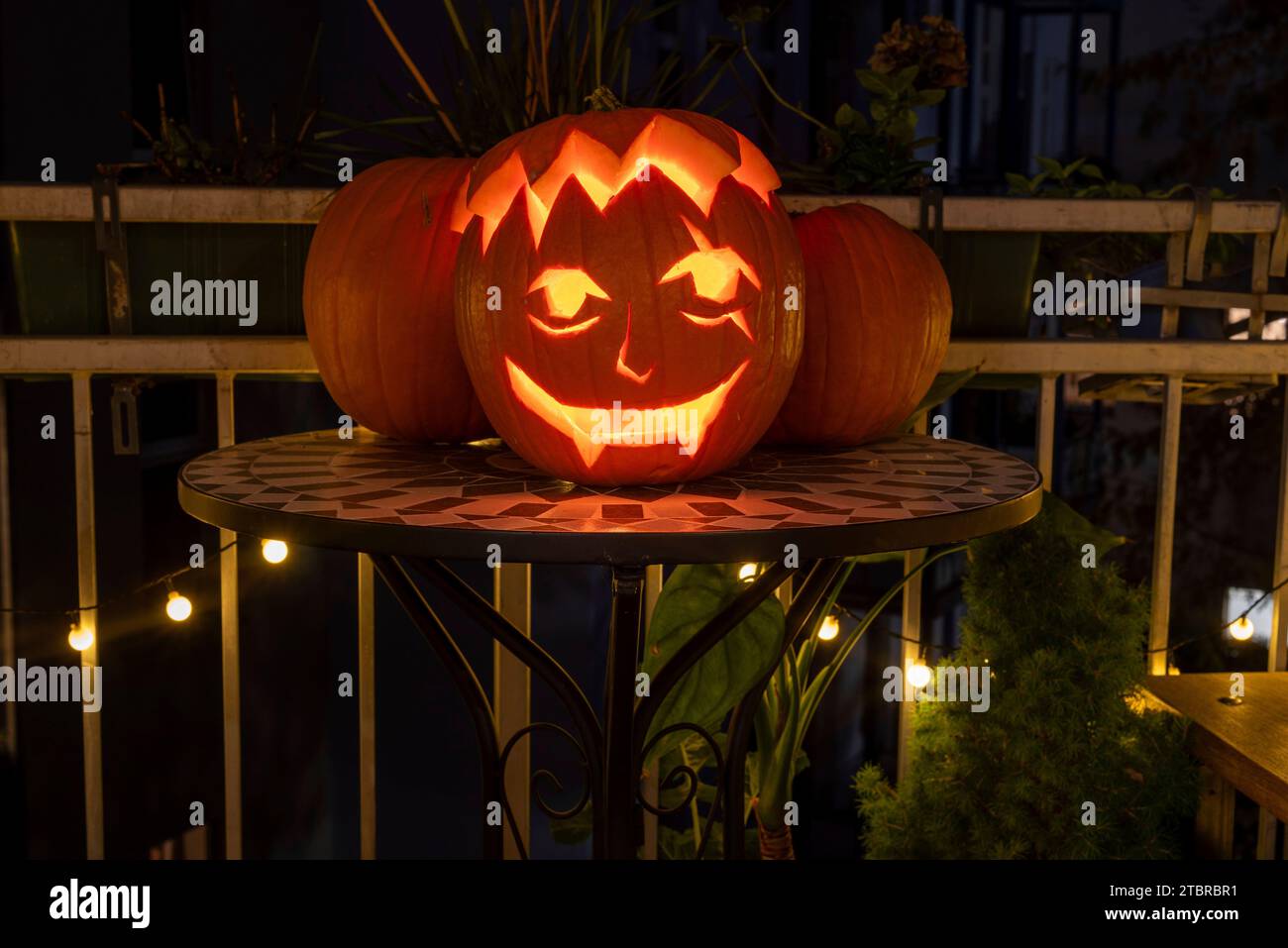 Una zucca intagliata si erge su un balcone la sera di Halloween, in Germania Foto Stock