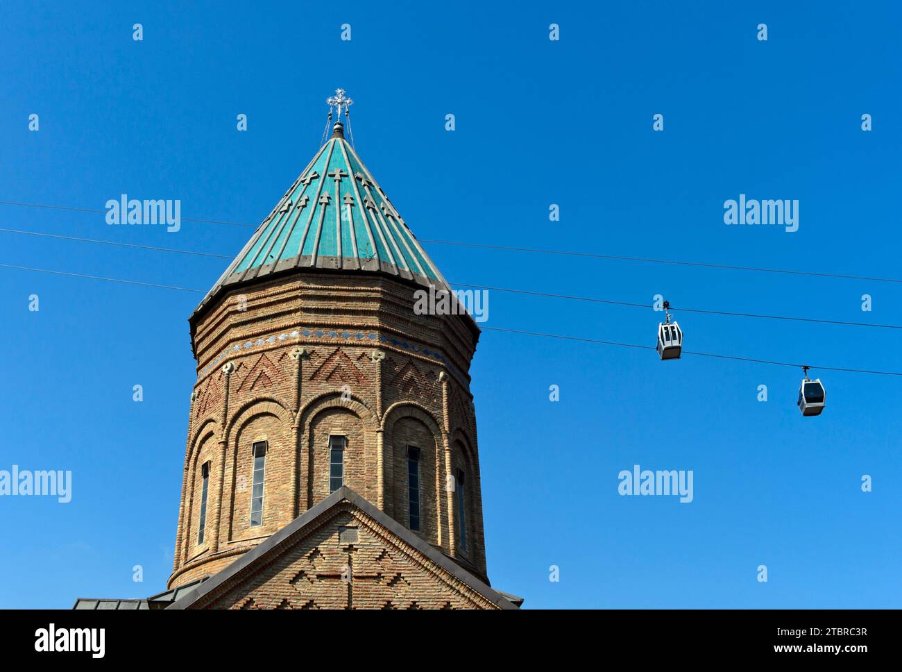 Due cabine della funivia Rike-Narikala passano davanti alla torre di St George's Armenian Church, Tbilisi, Georgia Foto Stock
