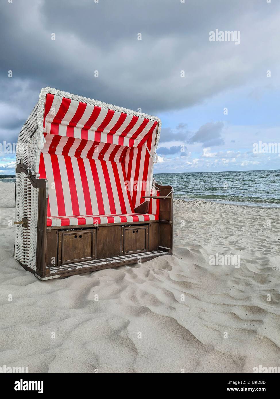 Germania, Meclemburgo-Pomerania Occidentale, Prerow, formazione di nubi sulla spiaggia sulla costa del Mar Baltico, atmosfera da temporale, nuvola di pioggia su sdraio rosso e bianco Foto Stock