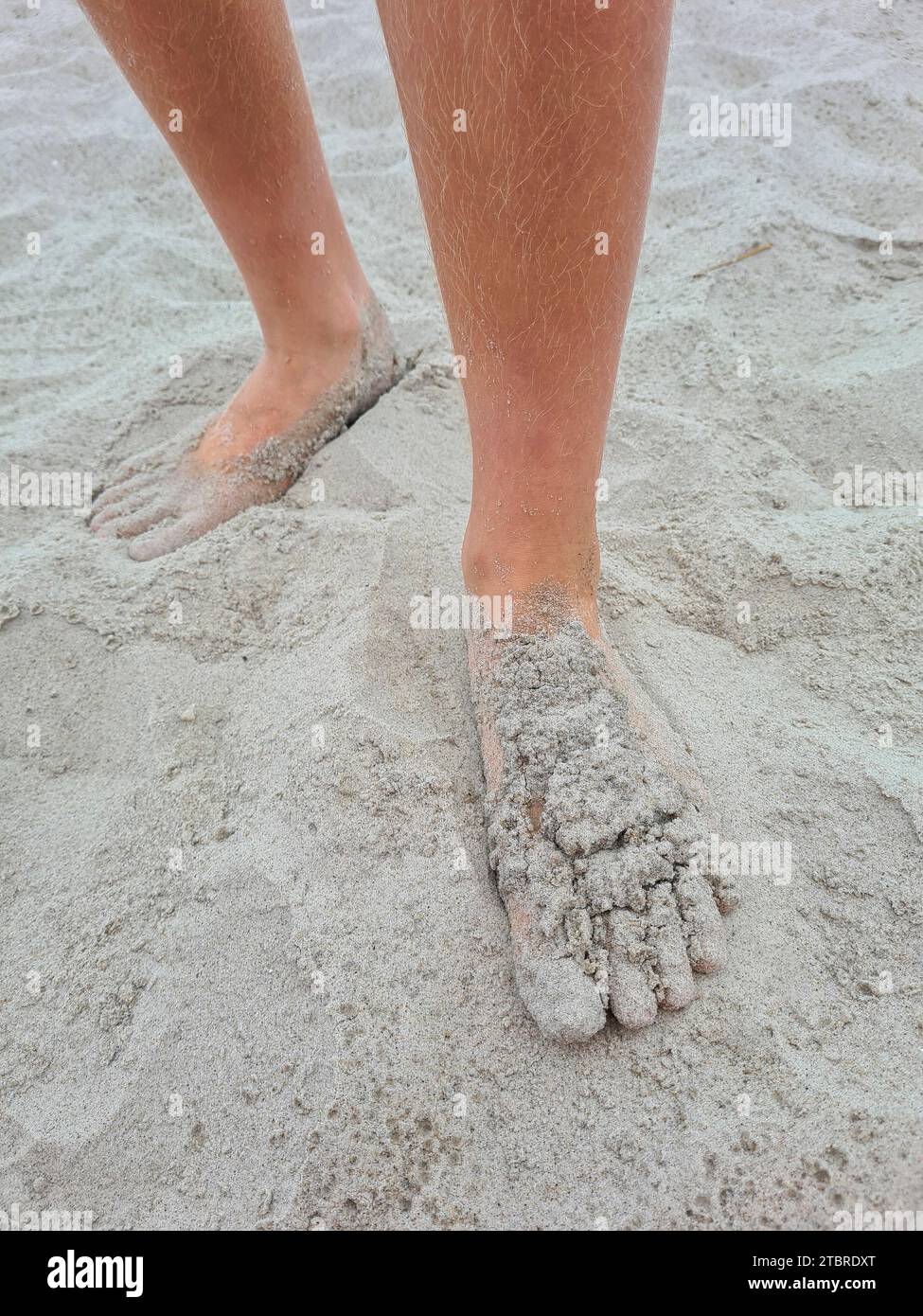 Germania, Meclemburgo-Pomerania occidentale, penisola Fischland-Darß-Zingst, piedi umani coperti di sabbia sulla spiaggia sabbiosa di Prerow Foto Stock