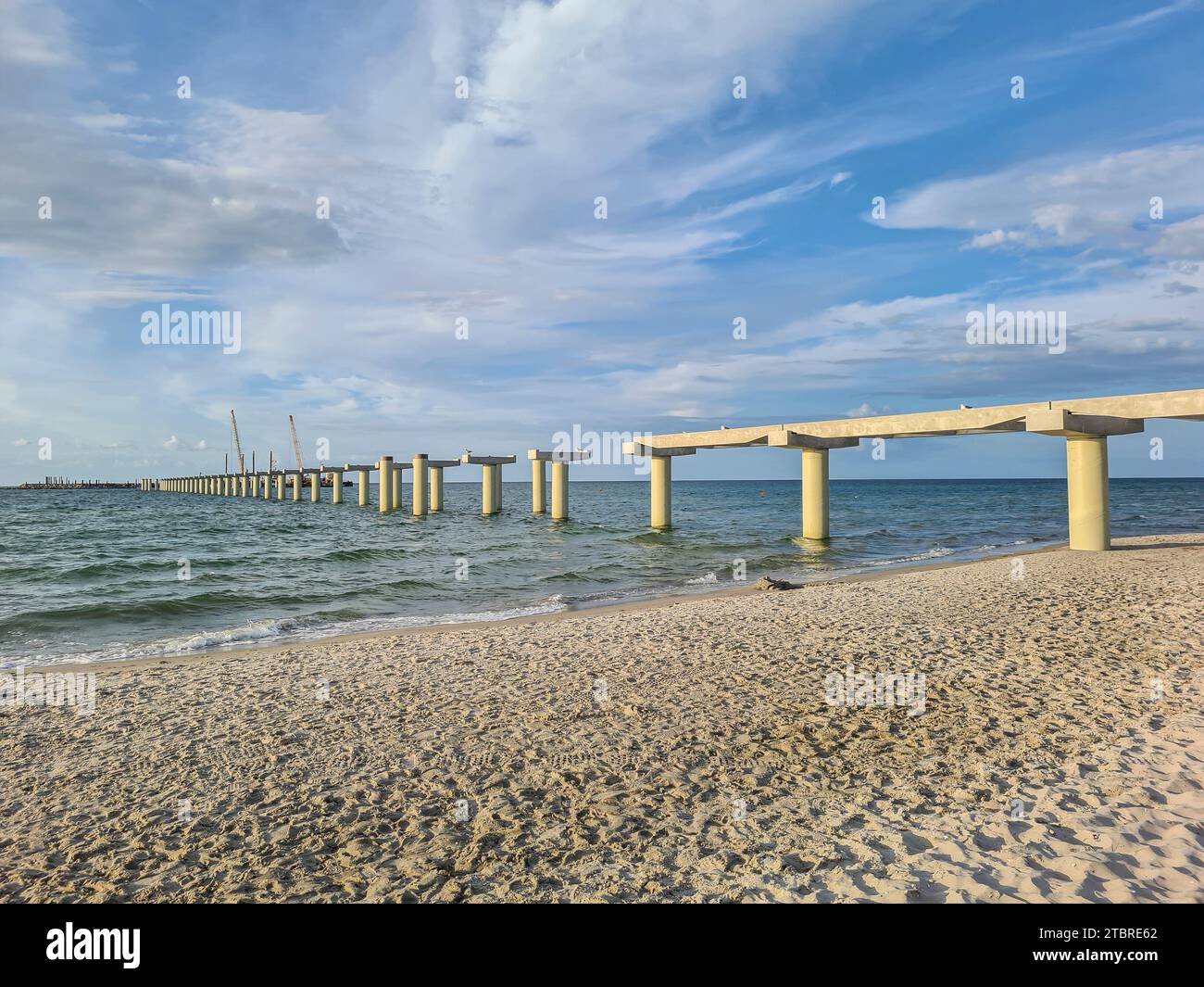 I pilastri in cemento del nuovo molo sulla spiaggia di sabbia fine nella soleggiata luce della sera, resort Baltico di Prerow, penisola di Fischland-Darß-Zingst, Meclemburgo-Pomerania occidentale, Germania Foto Stock