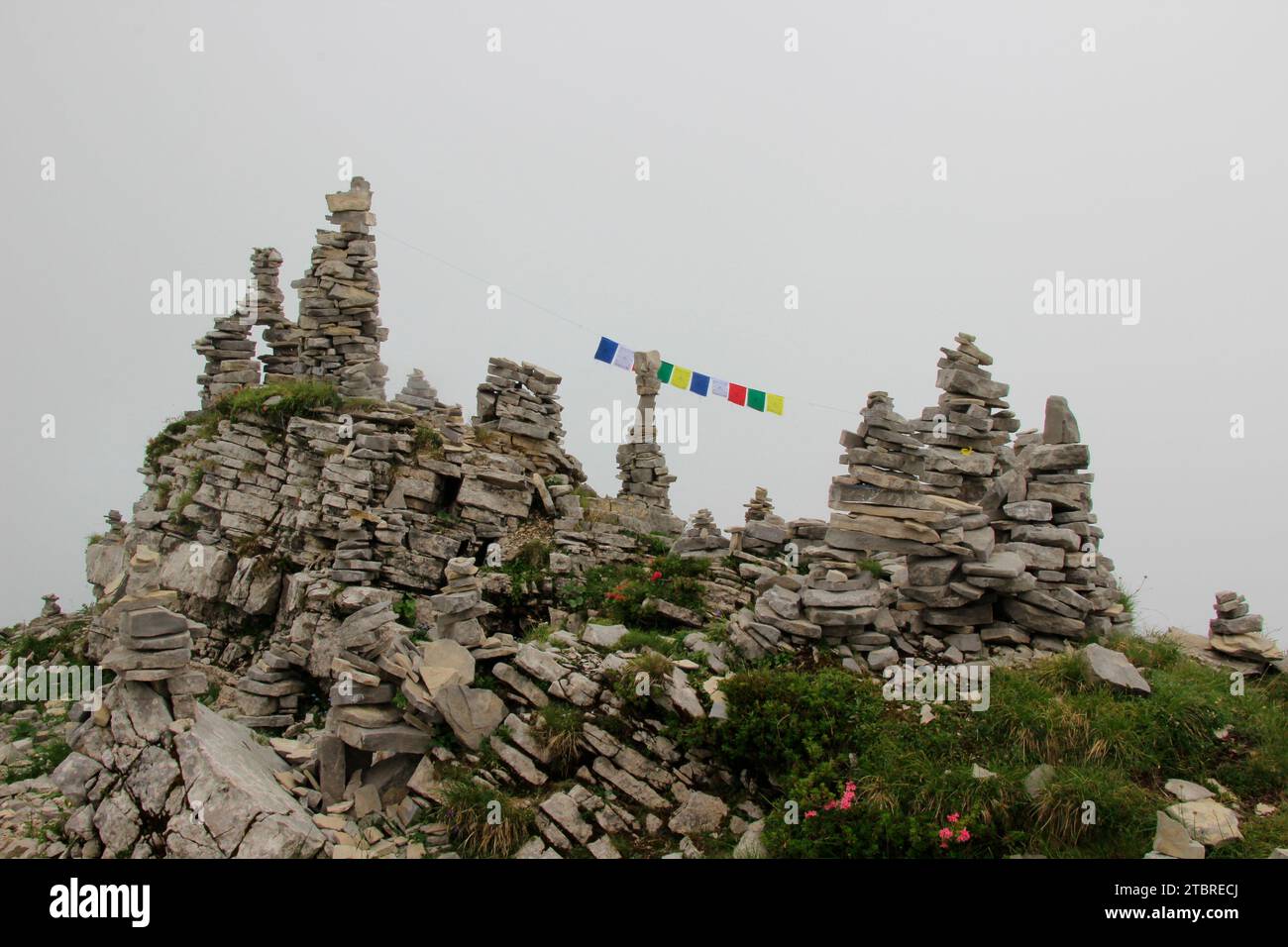 Bergmandl con bandiere di preghiera tibetane in densa svegliarsi sulla strada per la cima dello Schafreuter (2,102 m) nel Karwendelgebirge, Lenggries, Tölzer la Foto Stock