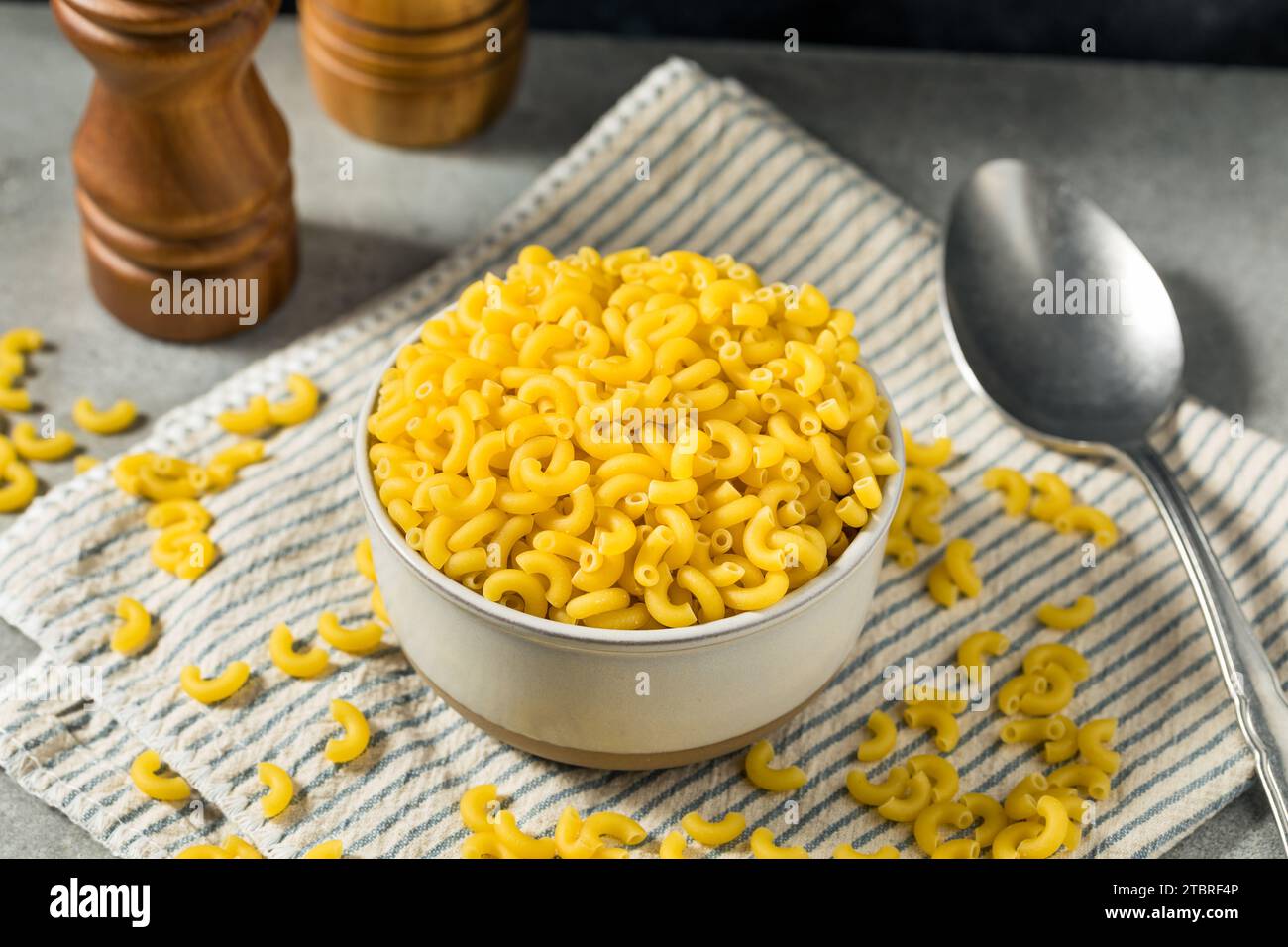 Tagliatelle crude di maccheroni crude biologiche in ciotola Foto Stock