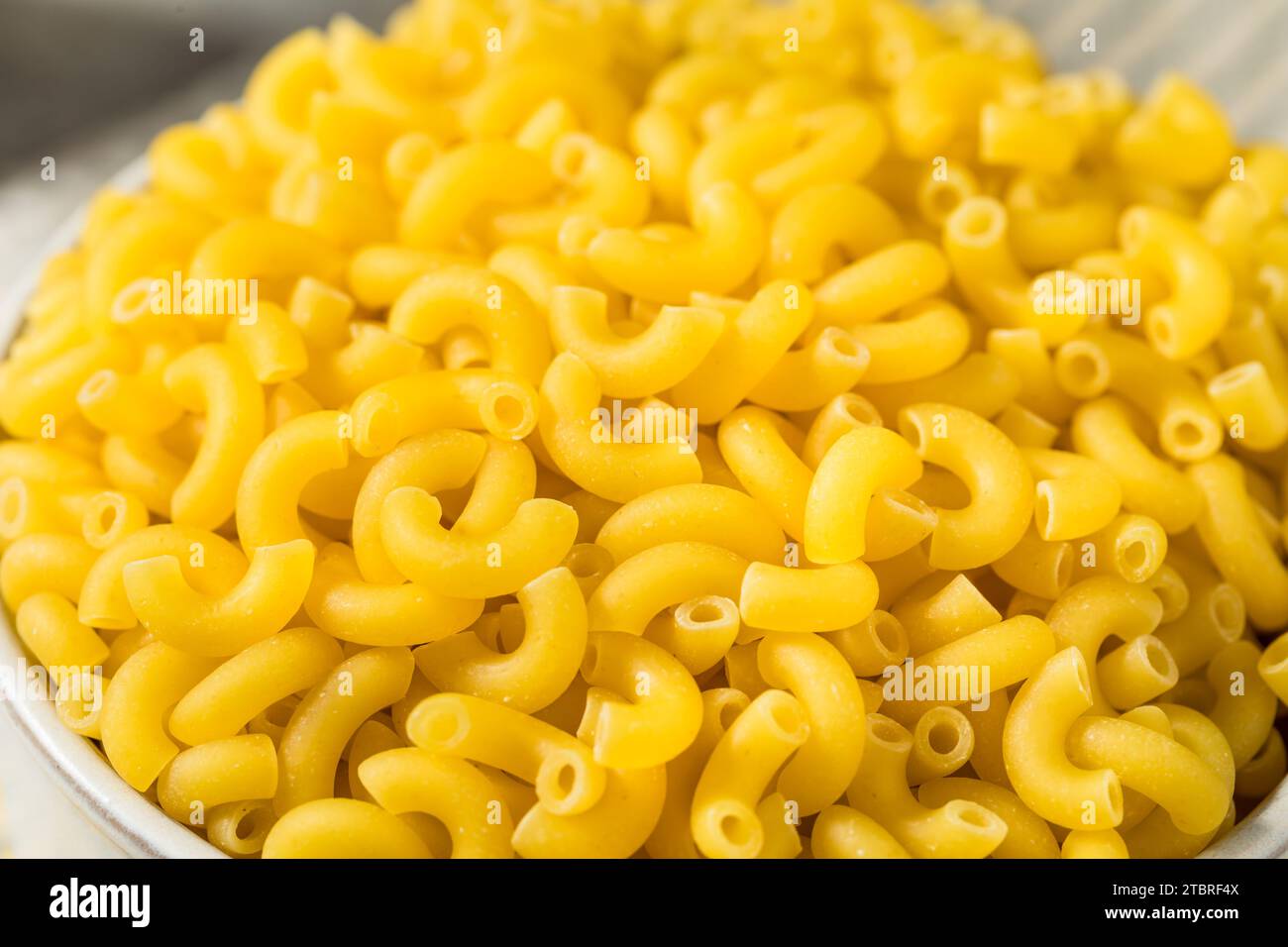 Tagliatelle crude di maccheroni crude biologiche in ciotola Foto Stock