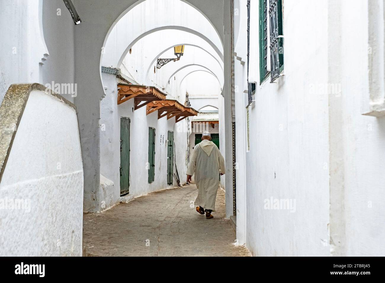 Uomo musulmano marocchino che indossa la tradizionale djellaba / jillaba islamica a piedi nella medina della città di Tétouan / Tettawen, Marocco Foto Stock