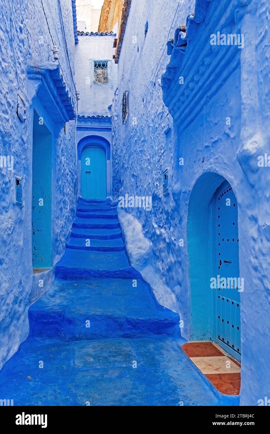 Vicolo stretto con mura blu, case e porte in medina / centro storico della città di Chefchaouen / Chaouen, Marocco Foto Stock
