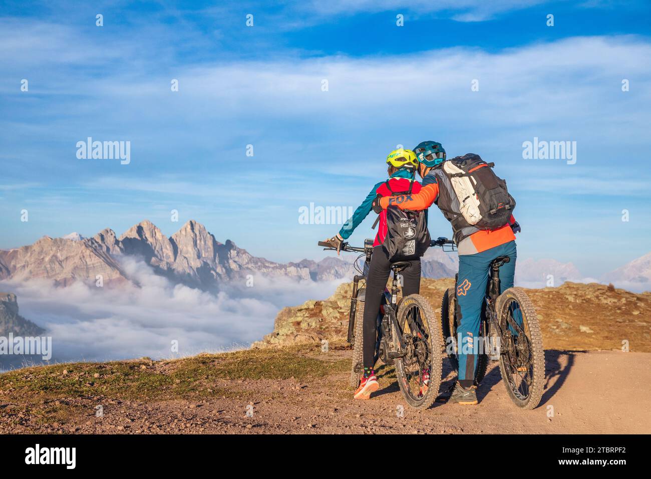 Italia, Veneto, provincia di Belluno, Falcade, attività all'aperto con famiglia, padre e figlia durante un tour in e-bike con sosta per ammirare le montagne al tramonto Foto Stock