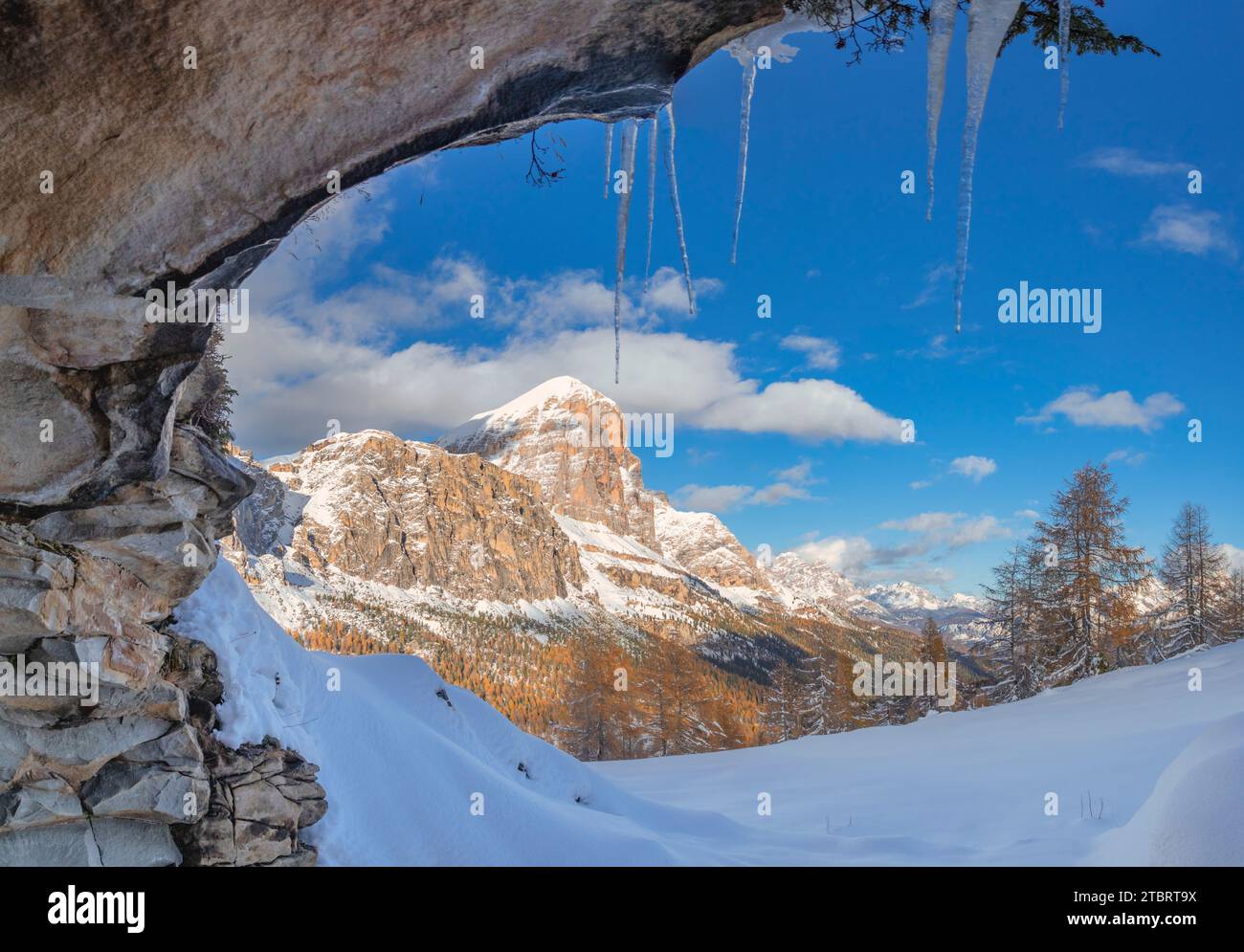 Italia, Veneto, provincia di Belluno, vista invernale della Tofana di Rozes da una grotta rocciosa con i ghiaccioli appesi dall'alto, Dolomiti Foto Stock