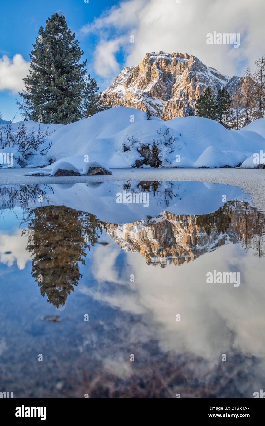 Italia, Veneto, provincia di Belluno, il Monte Lagazuoi si riflette in una pozza d'acqua ghiacciata, paesaggio invernale vicino al passo Falzarego, Dolomiti Foto Stock