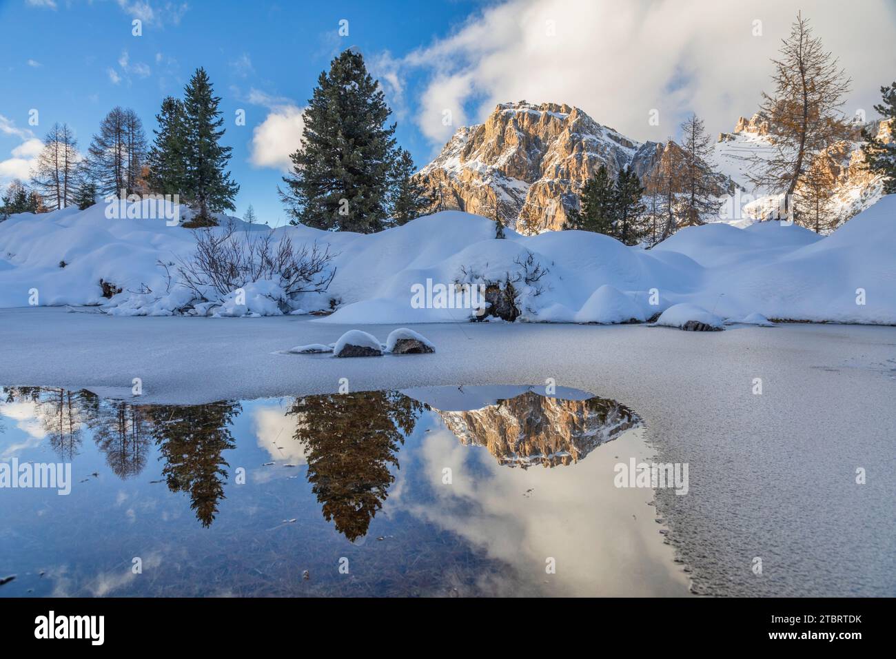 Italia, Veneto, provincia di Belluno, il Monte Lagazuoi si riflette in una pozza d'acqua ghiacciata, paesaggio invernale vicino al passo Falzarego, Dolomiti Foto Stock