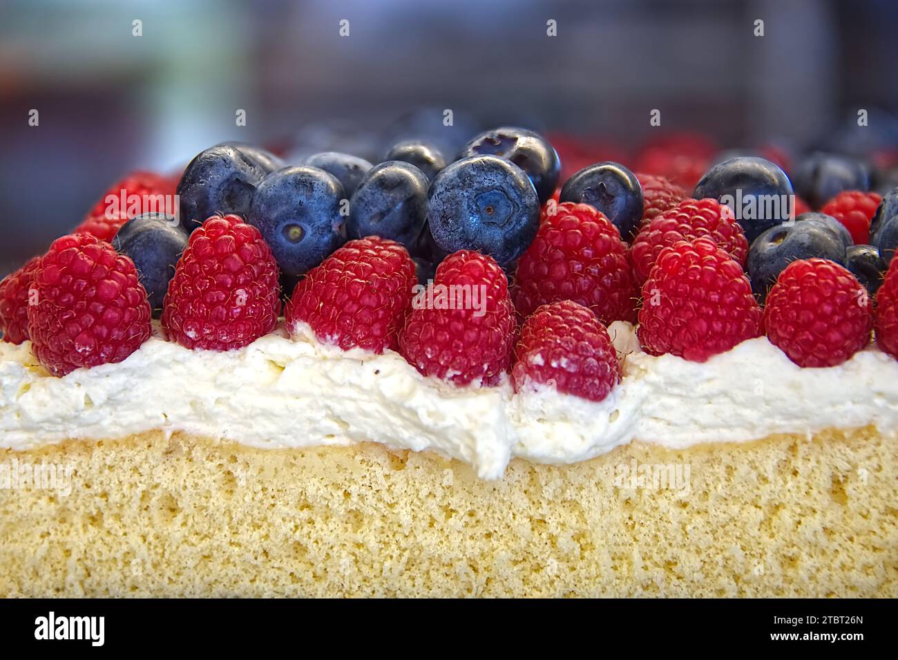 Vicino alla vista di una torta con fragole, mirtilli e panna Foto Stock