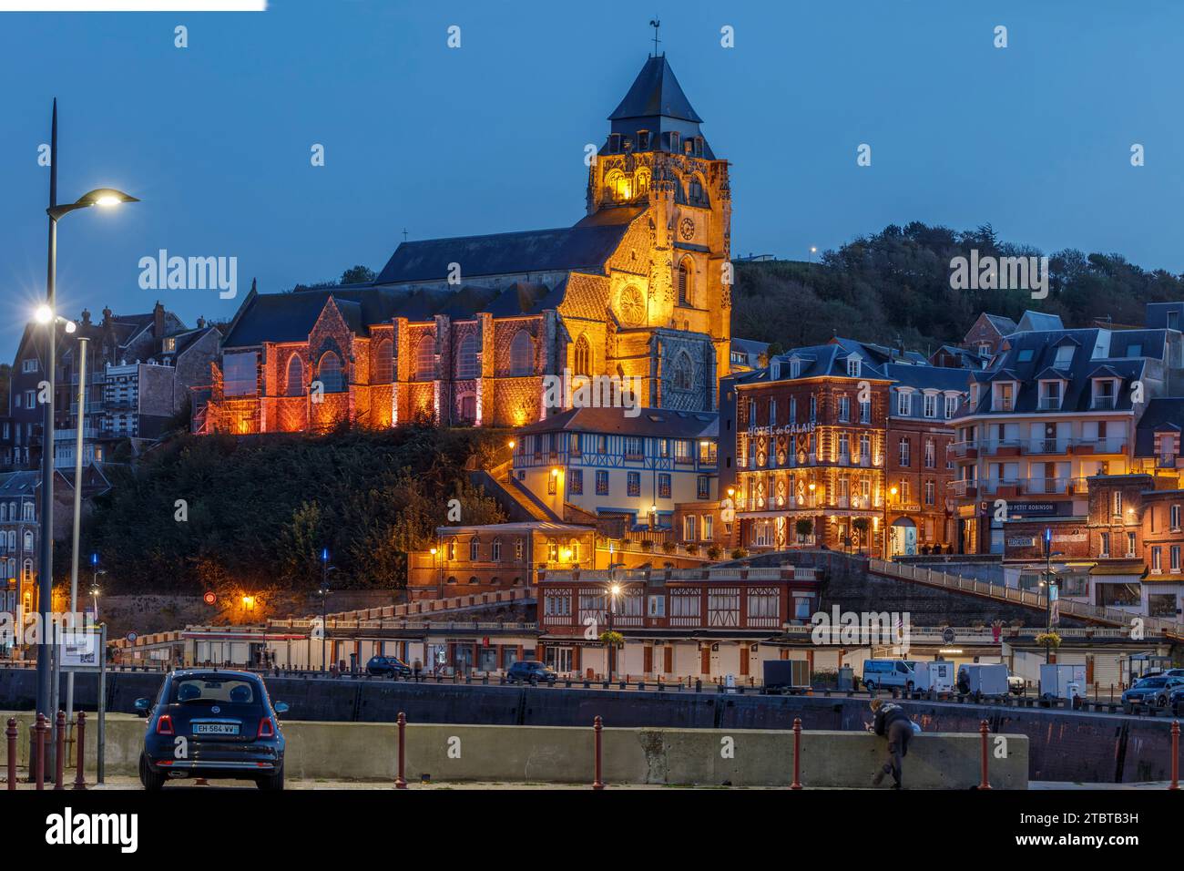 Francia, Normandia, le Tréport, vista dalla zona del porto alla città e la serata illuminata Église Saint-Jacques, crepuscolo, foto notturne Foto Stock
