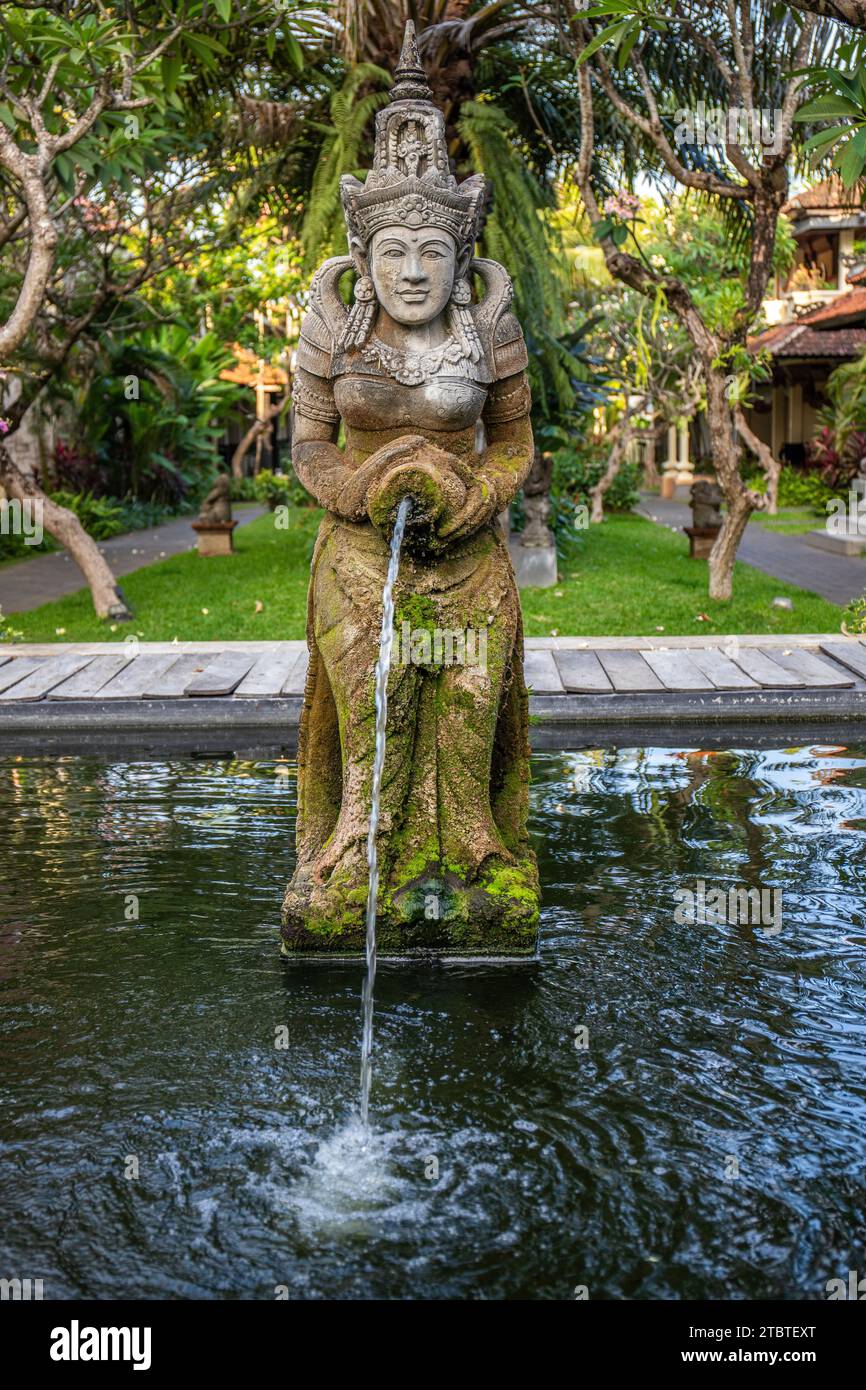 Parco con piante tropicali e statue tradizionali della fede indù e, per decorazione, vita isolana tropicale come turista a Bali, Indonesia Foto Stock