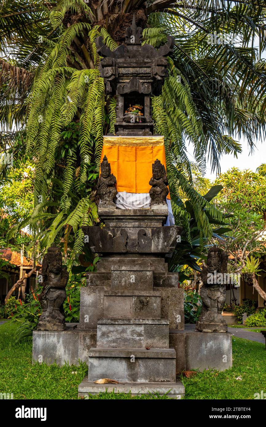 Parco con piante tropicali e statue tradizionali della fede indù e, per decorazione, vita isolana tropicale come turista a Bali, Indonesia Foto Stock