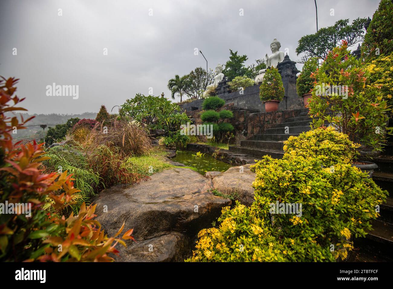 Tempio buddista di sera sotto la pioggia, il tempio Brahmavihara-Arama ha splendidi giardini ed è anche sede di un monastero, piante tropicali vicino a Banjar, Bali Foto Stock